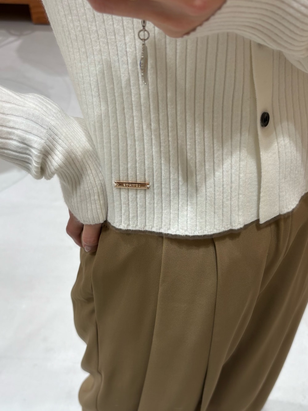 ホワイト系のカーディガン/ボレロ、イエロー系のその他パンツ、ブラック系のショルダーバッグを着用したレディースの冬コーディネートの3枚目の写真