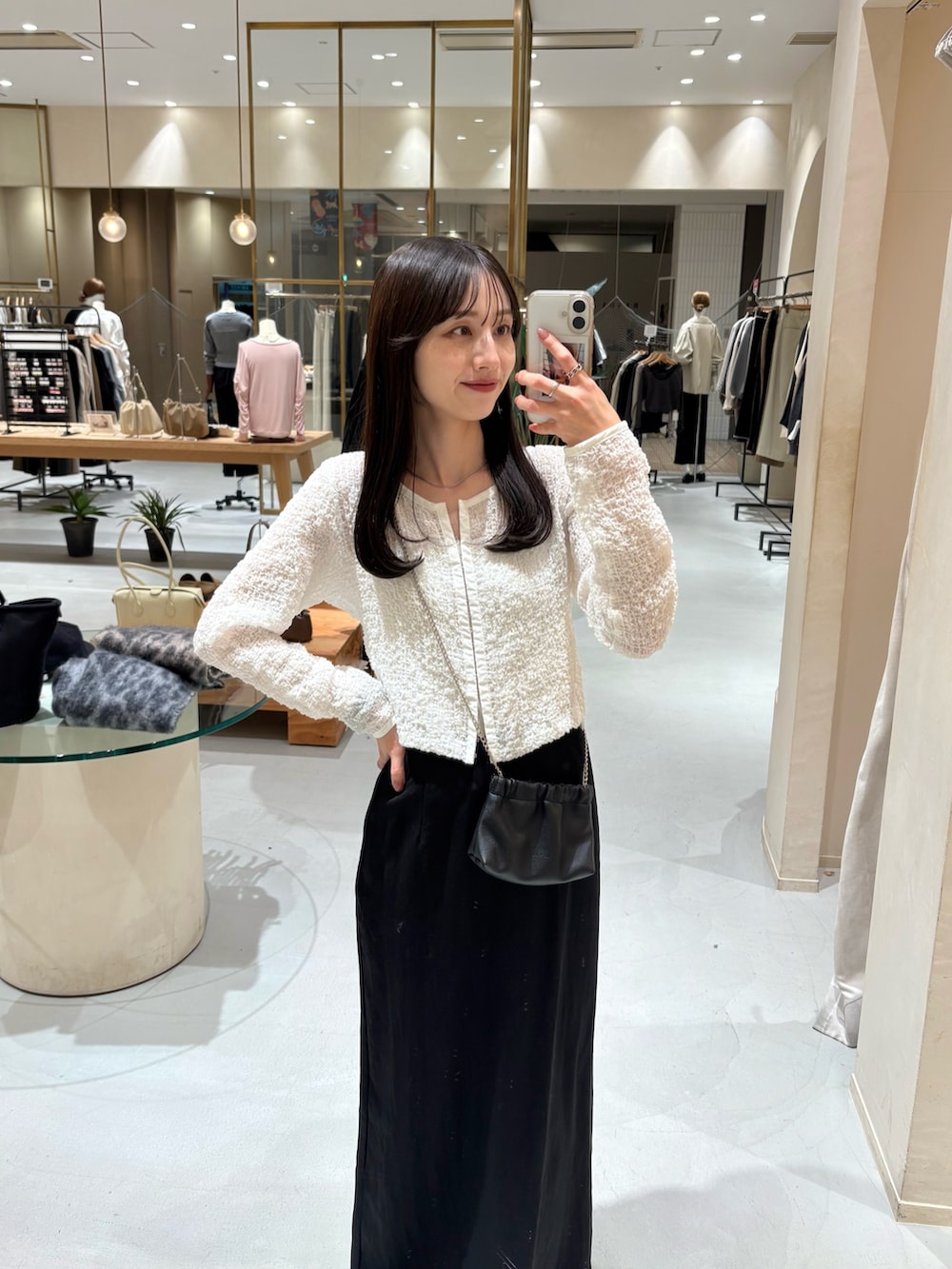 ブラック系のショルダーバッグ、ブラック系のスカート、ホワイト系のシャツ/ブラウスを着用したレディースの春コーディネートの2枚目の写真