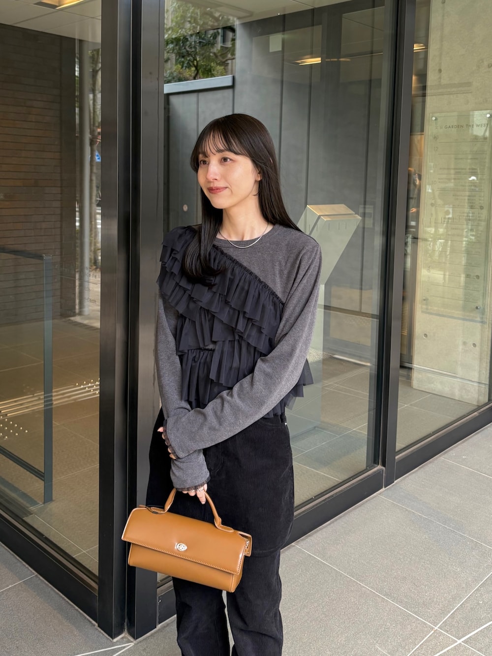 ブラック系のスカート、ブラック系のその他パンツ、グレー系のTシャツ/カットソーを着用したレディースの冬コーディネートの2枚目の写真