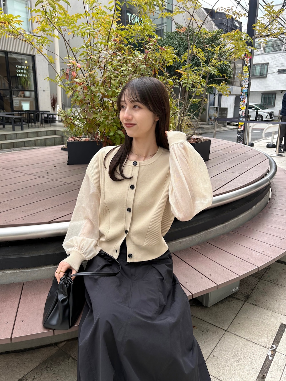 ブラック系のスカート、ベージュ系のカーディガン/ボレロ、ブラック系のパンプスを着用したレディースの春コーディネートの2枚目の写真