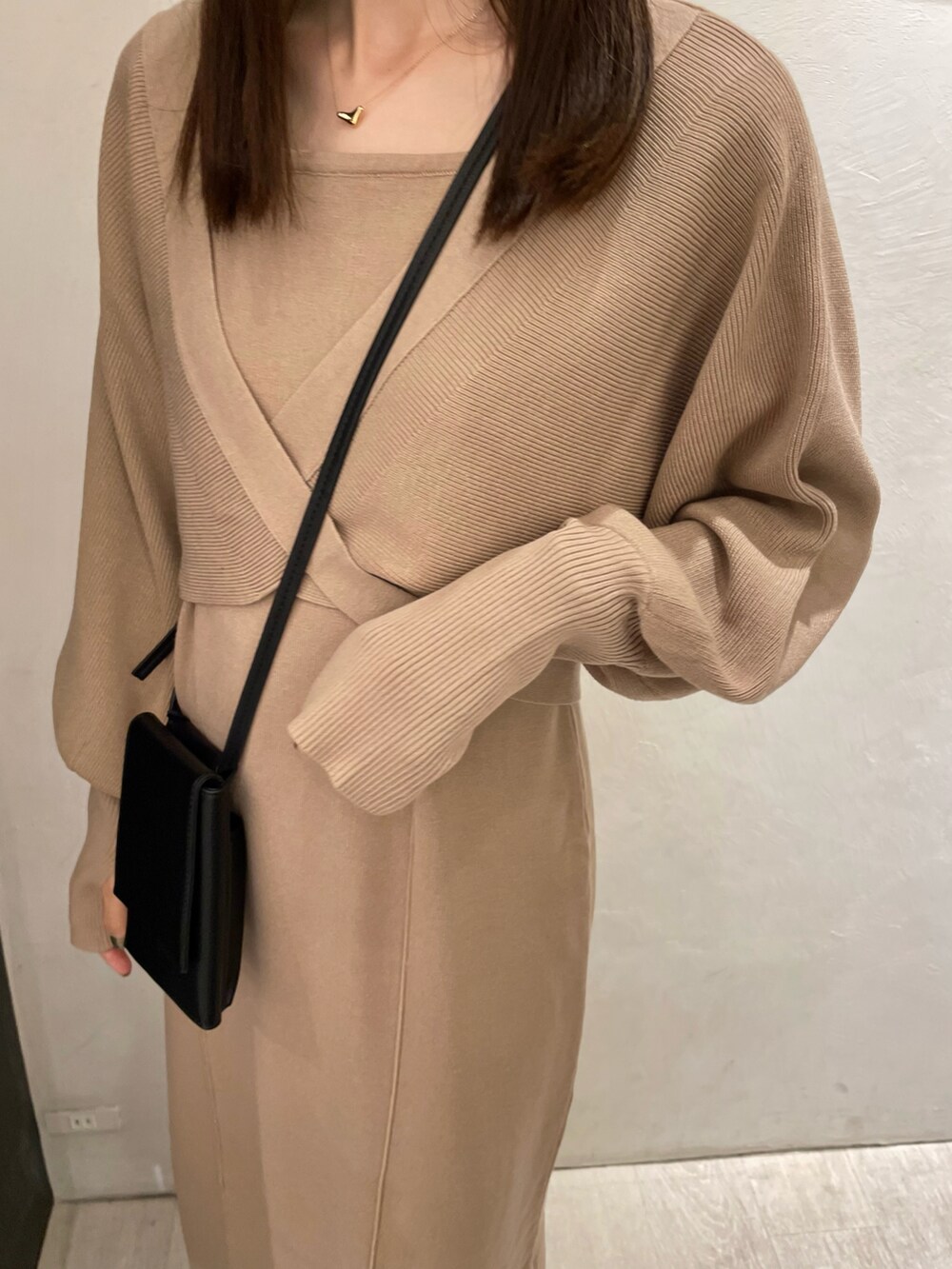 ベージュ系のワンピース、ブラック系のショルダーバッグ、ブラック系のブーツを着用したレディースの秋コーディネートの3枚目の写真