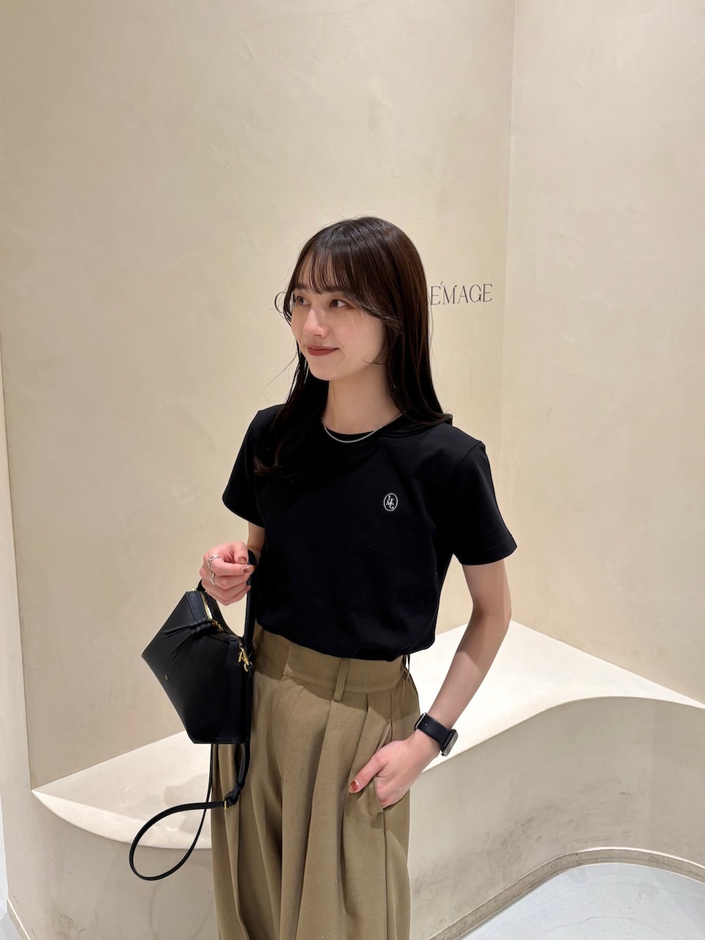 ベージュ系のその他パンツ、ブラック系のショルダーバッグ、ブラック系のTシャツ/カットソーを着用したレディースの春コーディネートの2枚目の写真