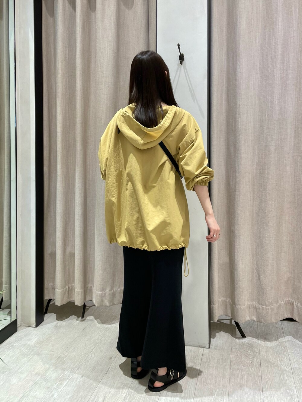 ブラック系のスカート、イエロー系のトップス、ブラック系のボディバッグ/ウエストポーチを着用したレディースの夏コーディネートの3枚目の写真