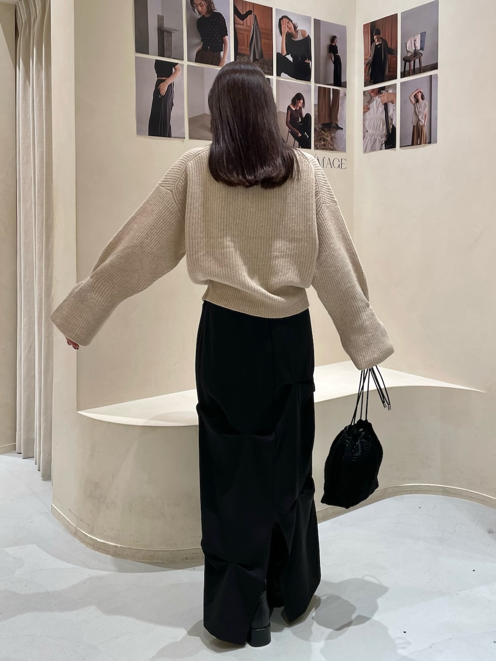 ベージュ系のカーディガン/ボレロ、ブラック系のスカート、ブラック系のブーツを着用したレディースの秋コーディネートの4枚目の写真