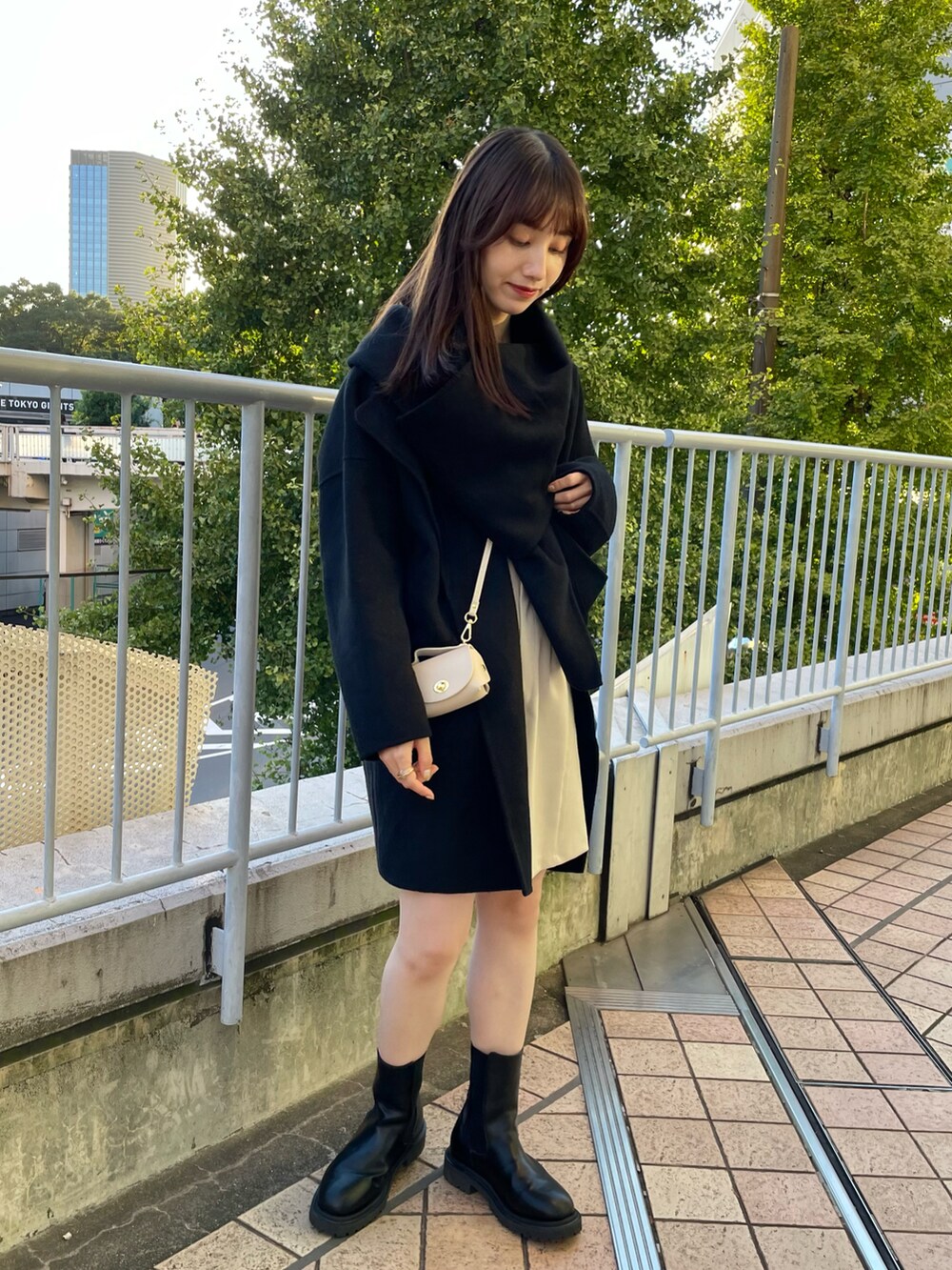 ブラック系のノーカラーコート、ホワイト系のその他パンツ、ブラック系のブーツを着用したレディースの秋コーディネートの2枚目の写真