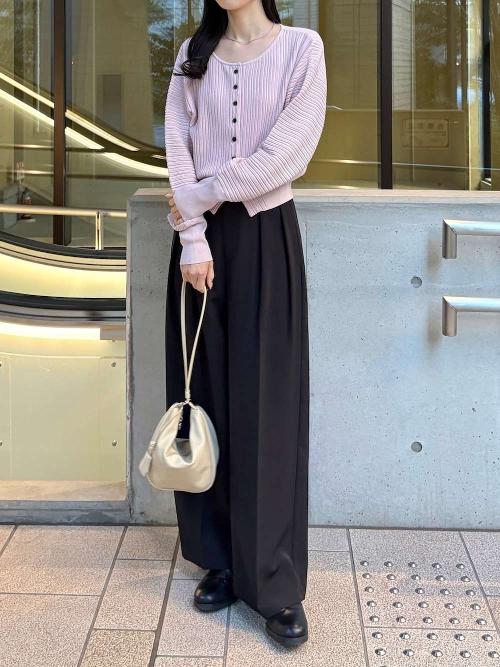 ブラック系のその他パンツ、ピンク系のカーディガン/ボレロ、ホワイト系のショルダーバッグを着用したレディースの春コーディネートの2枚目の写真