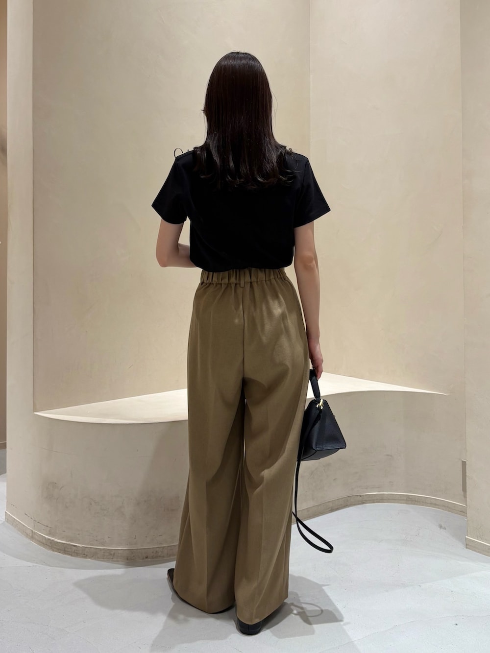 ベージュ系のその他パンツ、ブラック系のショルダーバッグ、ブラック系のTシャツ/カットソーを着用したレディースの春コーディネートの3枚目の写真