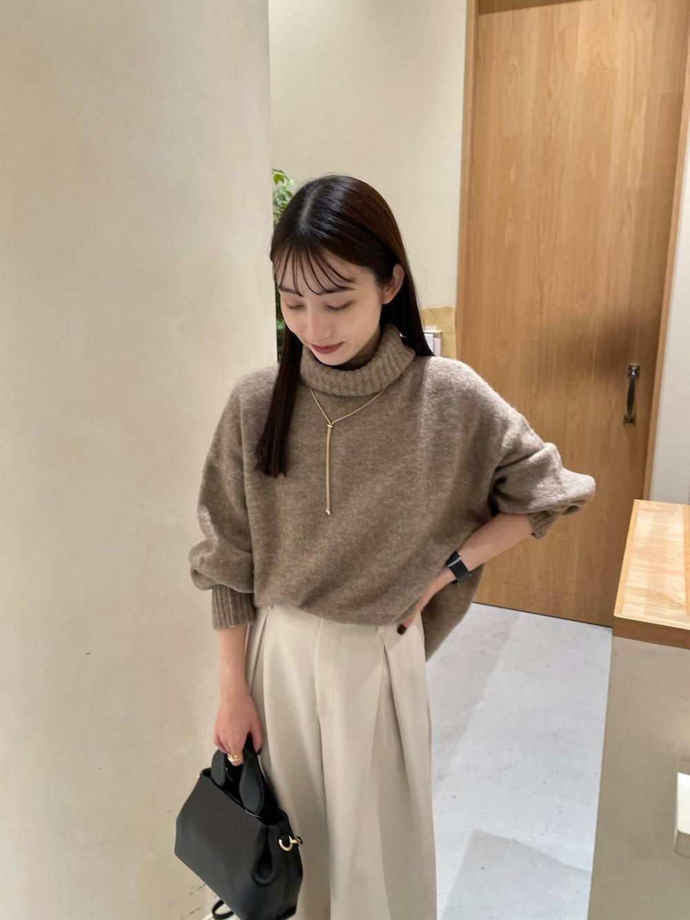 ブラック系のショルダーバッグ、ブラック系のパンプス、ホワイト系のその他パンツを着用したレディースの秋コーディネートの3枚目の写真