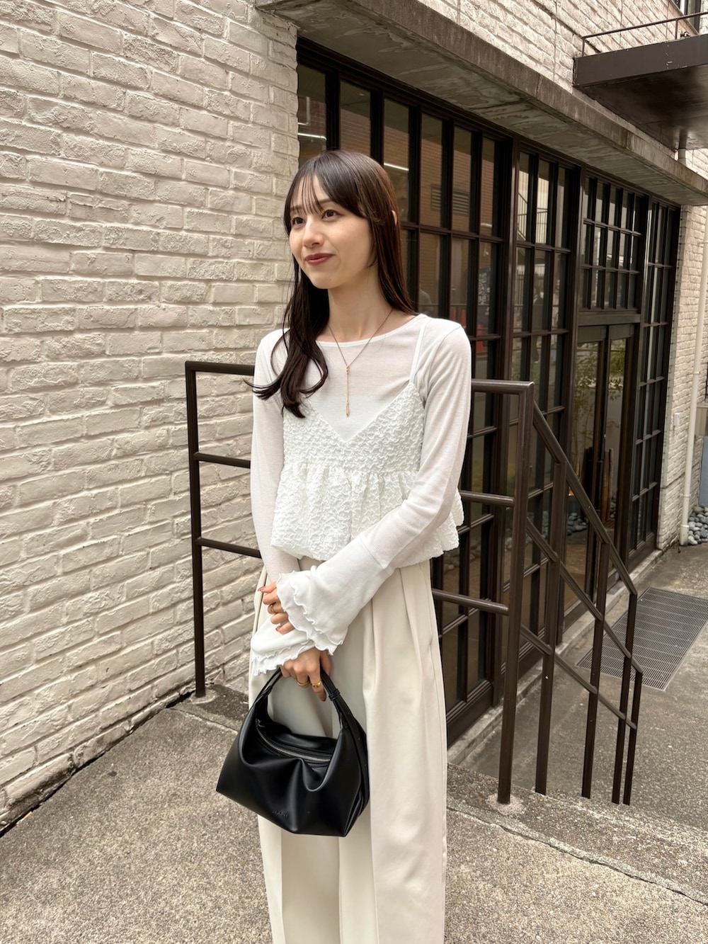 ホワイト系のその他パンツ、ブラック系のショルダーバッグ、ホワイト系のシャツ/ブラウスを着用したレディースの春コーディネートの2枚目の写真