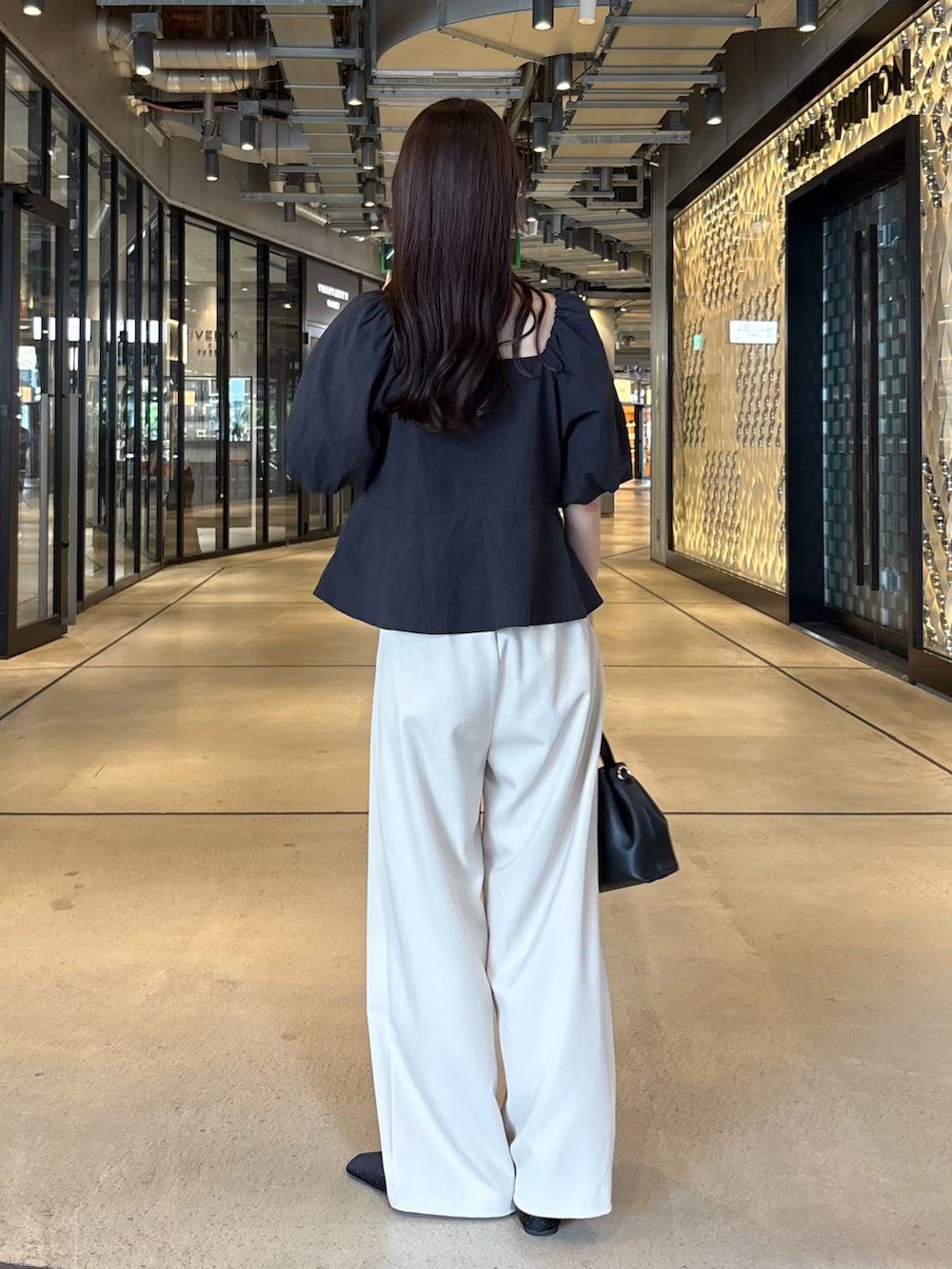 ベージュ系のその他パンツ、ブラック系のシャツ/ブラウス、ブラック系のショルダーバッグを着用したレディースの夏コーディネートの4枚目の写真