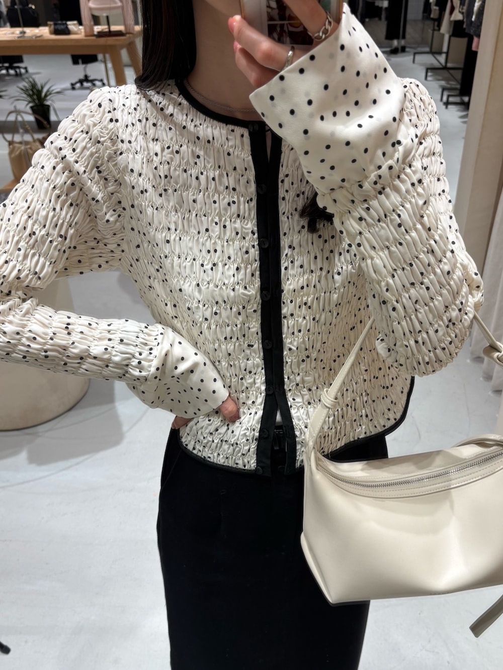 ホワイト系のショルダーバッグ、ホワイト系のシャツ/ブラウス、ブラック系のスカートを着用したレディースの春コーディネートの3枚目の写真