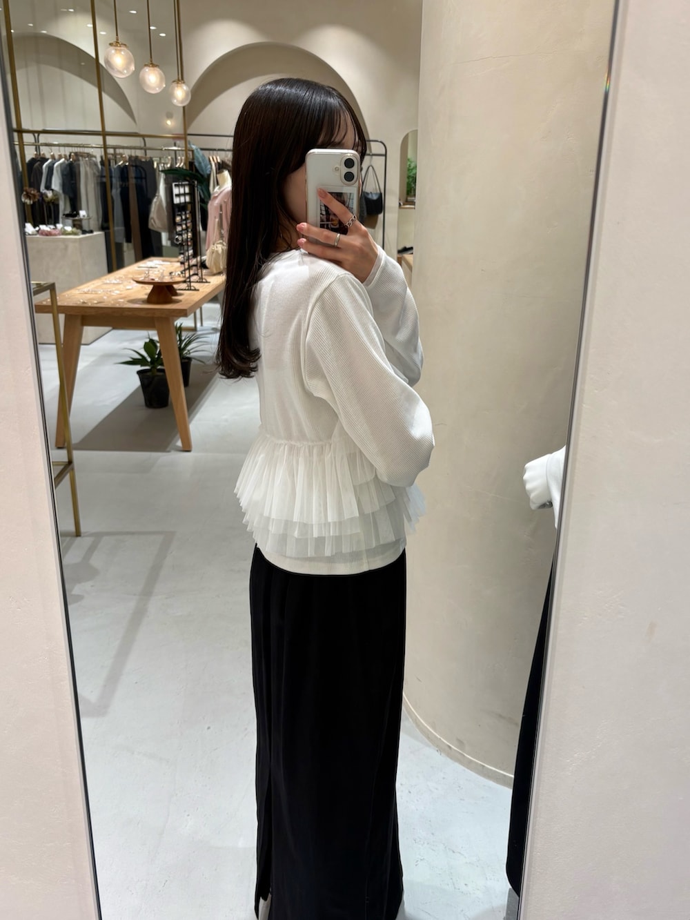 ブラック系のスカート、ホワイト系のTシャツ/カットソー、ブラウン系のショルダーバッグを着用したレディースの春コーディネートの4枚目の写真