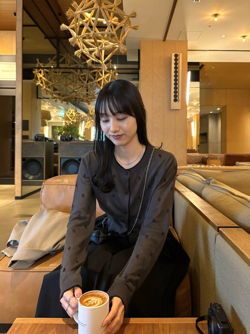 ブラック系のスカート、ブラック系のパンプス、グレー系のカーディガン/ボレロを着用したレディースの春コーディネートの2枚目の写真