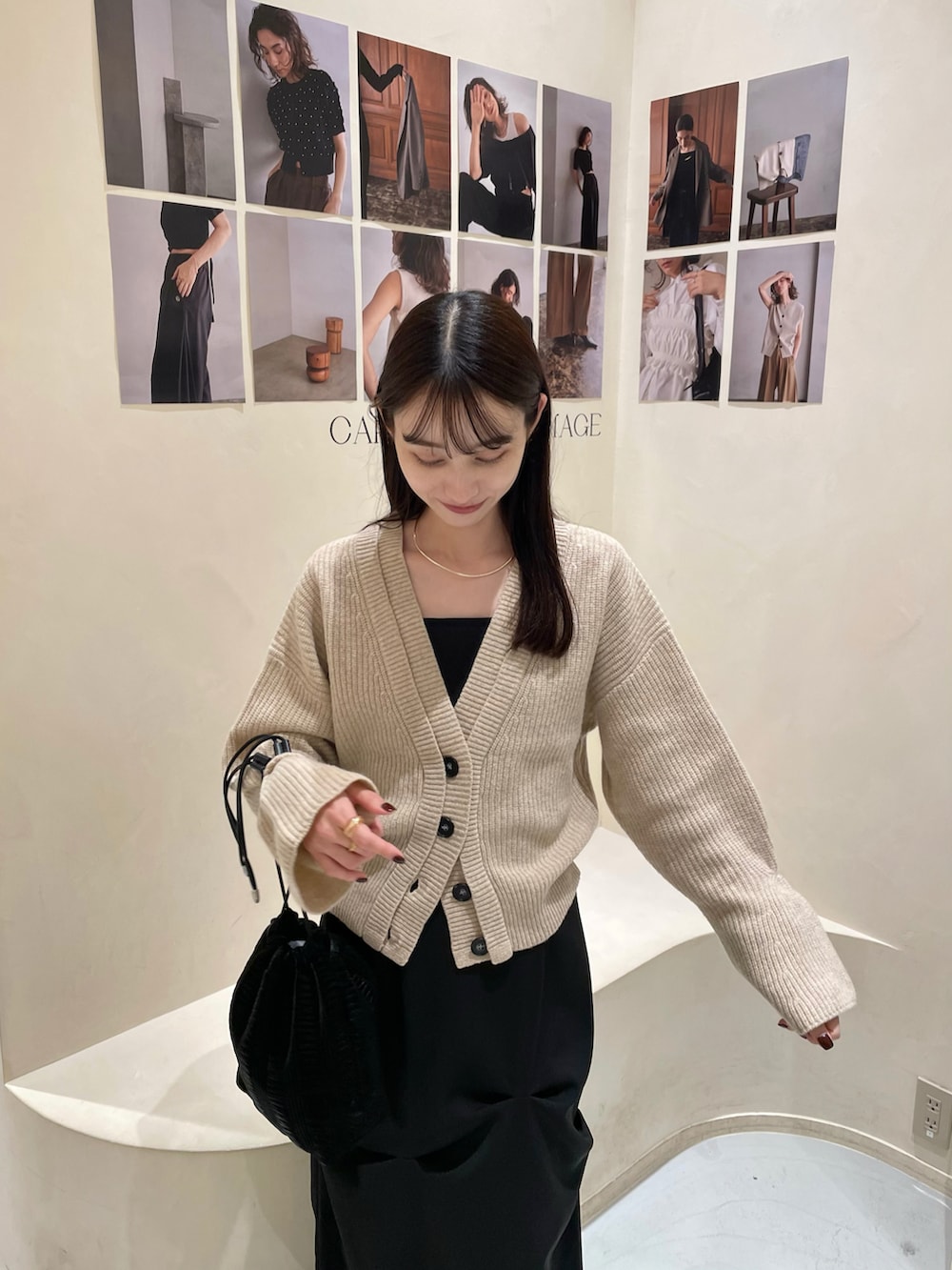 ベージュ系のカーディガン/ボレロ、ブラック系のスカート、ブラック系のブーツを着用したレディースの秋コーディネートの3枚目の写真