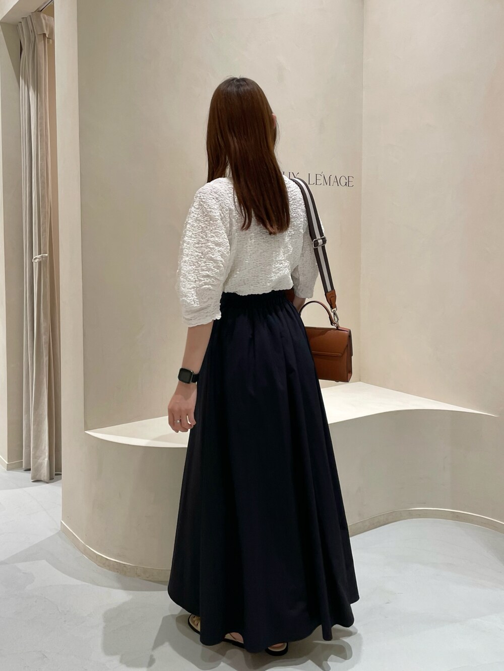 ホワイト系のTシャツ/カットソー、ブラック系のスカートを着用したレディースの夏コーディネートの3枚目の写真