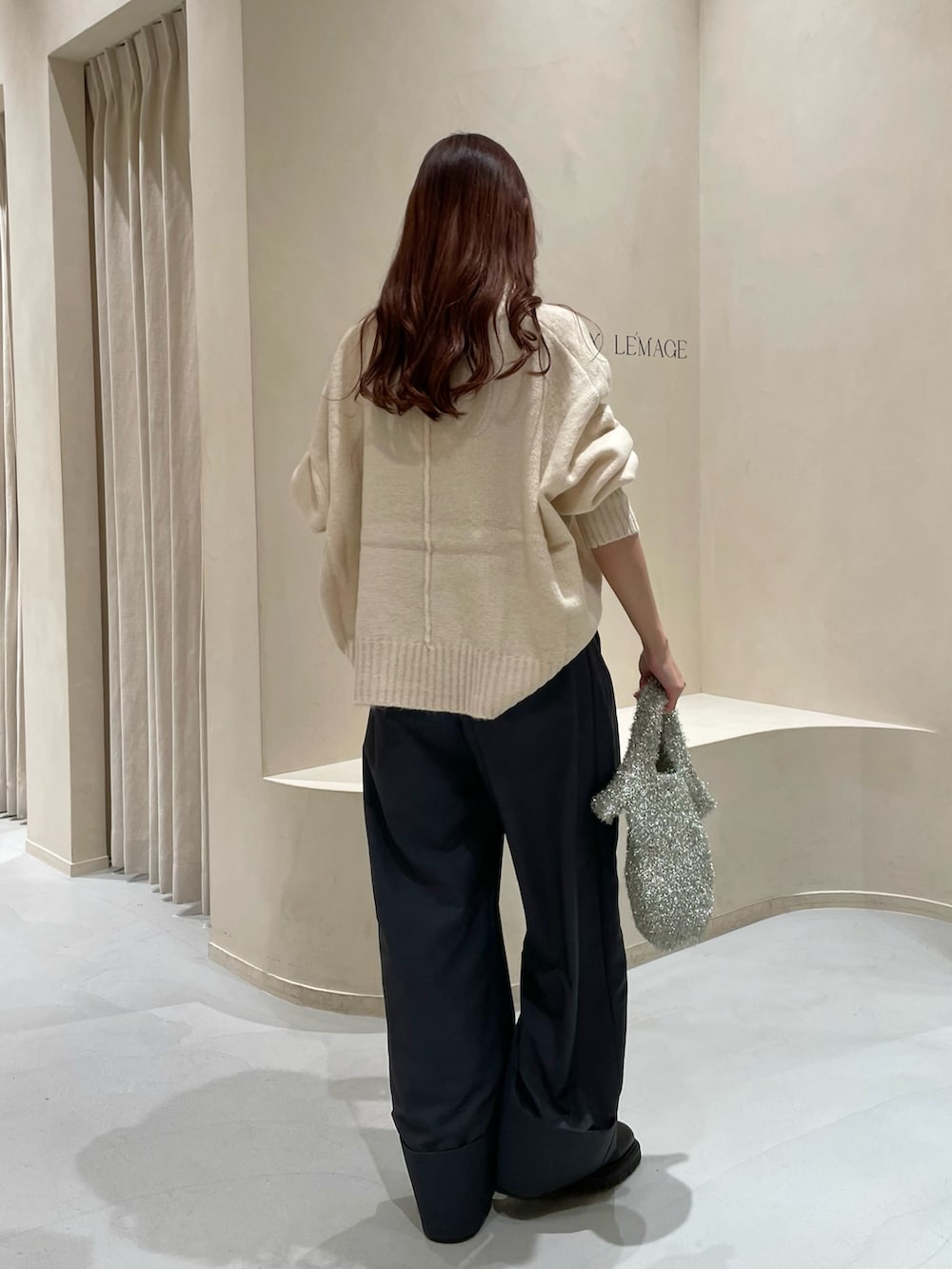 グレー系のその他パンツ、ホワイト系のニット/セーター、シルバー系のハンドバッグを着用したレディースの冬コーディネートの4枚目の写真