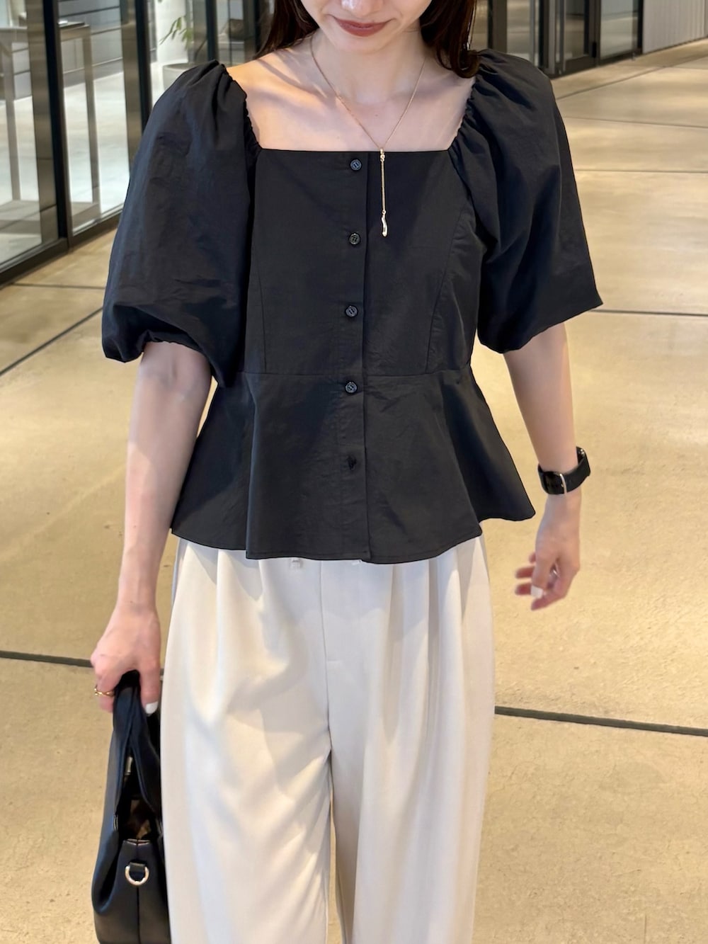 ベージュ系のその他パンツ、ブラック系のシャツ/ブラウス、ブラック系のショルダーバッグを着用したレディースの夏コーディネートの3枚目の写真