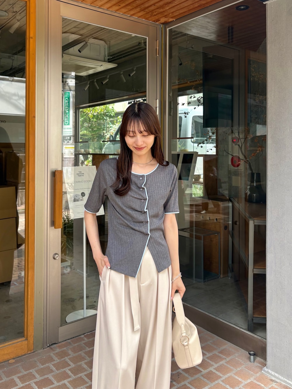 ホワイト系のその他パンツ、グレー系のTシャツ/カットソー、ホワイト系のショルダーバッグを着用したレディースの夏コーディネートの2枚目の写真