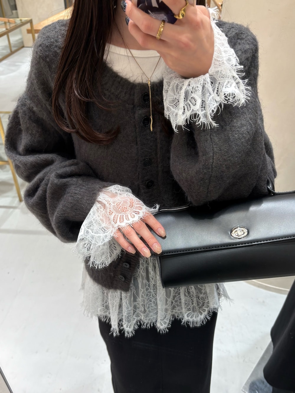 ブラック系のスカート、ブラック系のブーツ、ホワイト系のTシャツ/カットソーを着用したレディースの冬コーディネートの5枚目の写真