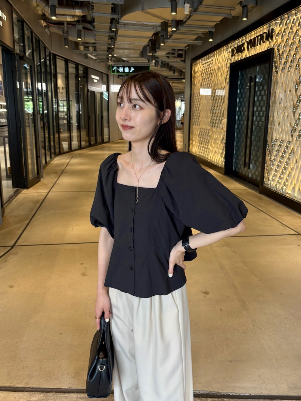 ベージュ系のその他パンツ、ブラック系のシャツ/ブラウス、ブラック系のショルダーバッグを着用したレディースの夏コーディネートの2枚目の写真