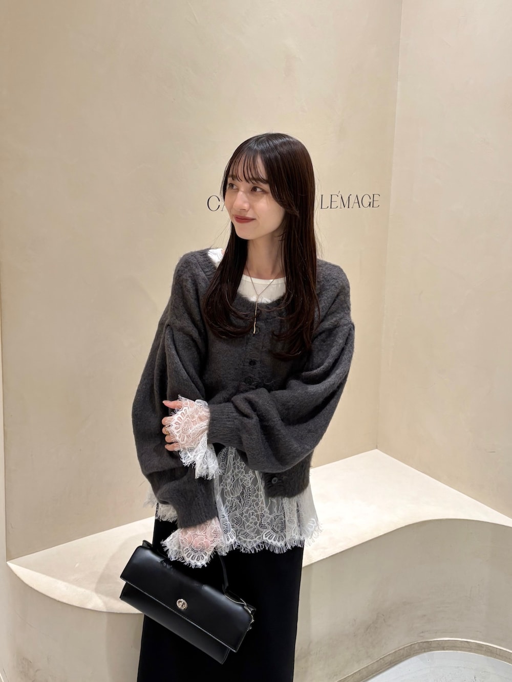 ブラック系のスカート、ブラック系のブーツ、ホワイト系のTシャツ/カットソーを着用したレディースの冬コーディネートの4枚目の写真