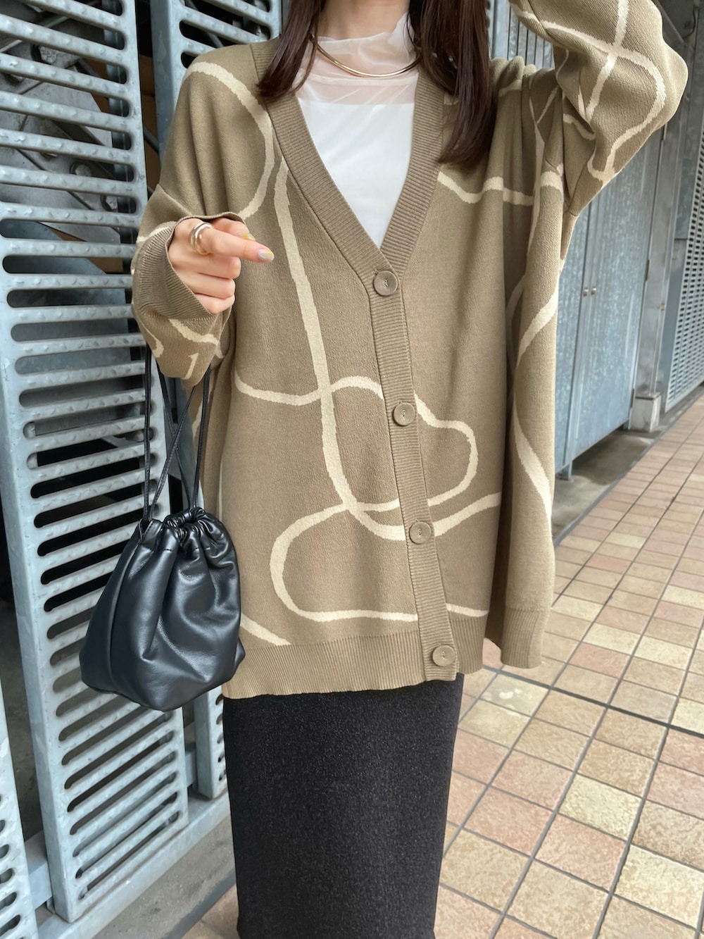 ベージュ系のカーディガン/ボレロ、ブラック系のスカート、ブラック系のブーツを着用したレディースの秋コーディネートの2枚目の写真