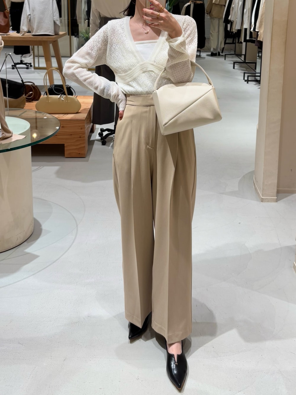 ベージュ系のその他パンツ、ホワイト系のハンドバッグ、ホワイト系のニット/セーターを着用したレディースの春コーディネートの3枚目の写真