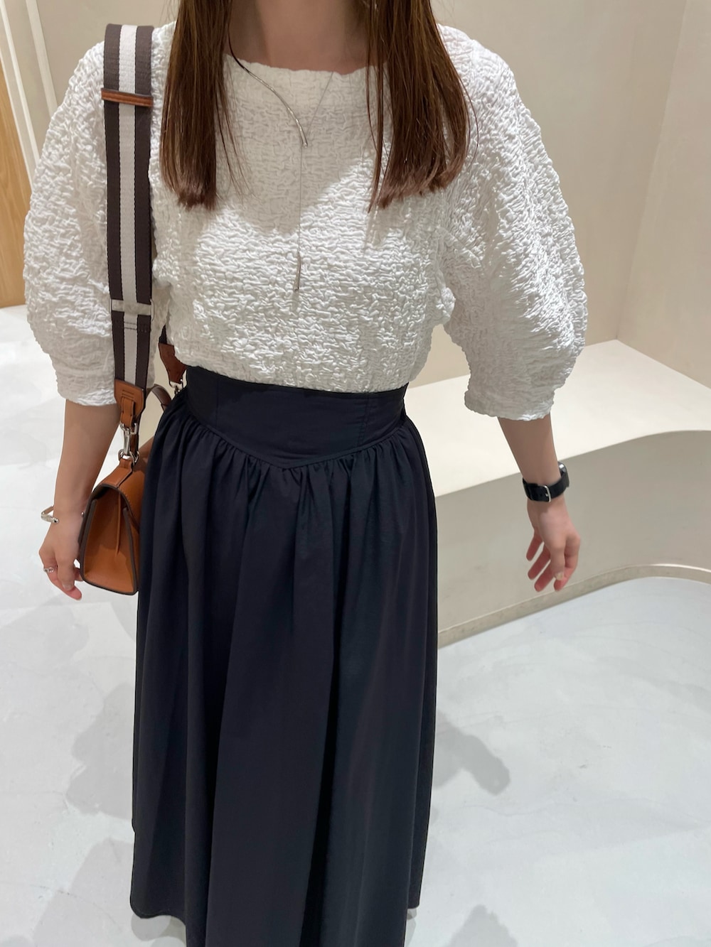 ホワイト系のTシャツ/カットソー、ブラック系のスカートを着用したレディースの夏コーディネートの2枚目の写真