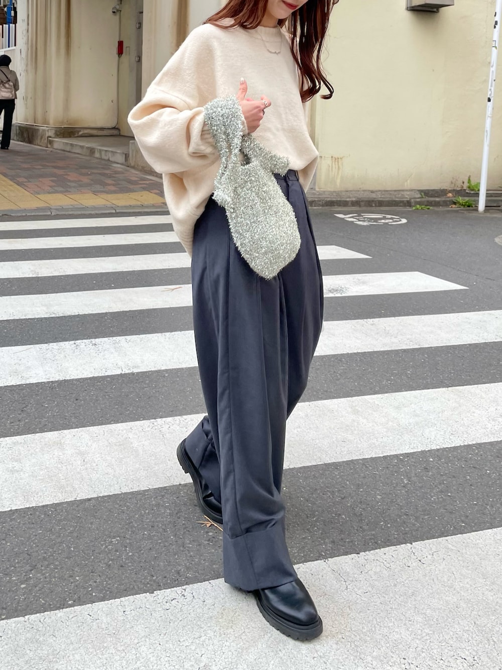 グレー系のその他パンツ、ホワイト系のニット/セーター、シルバー系のハンドバッグを着用したレディースの冬コーディネートの3枚目の写真