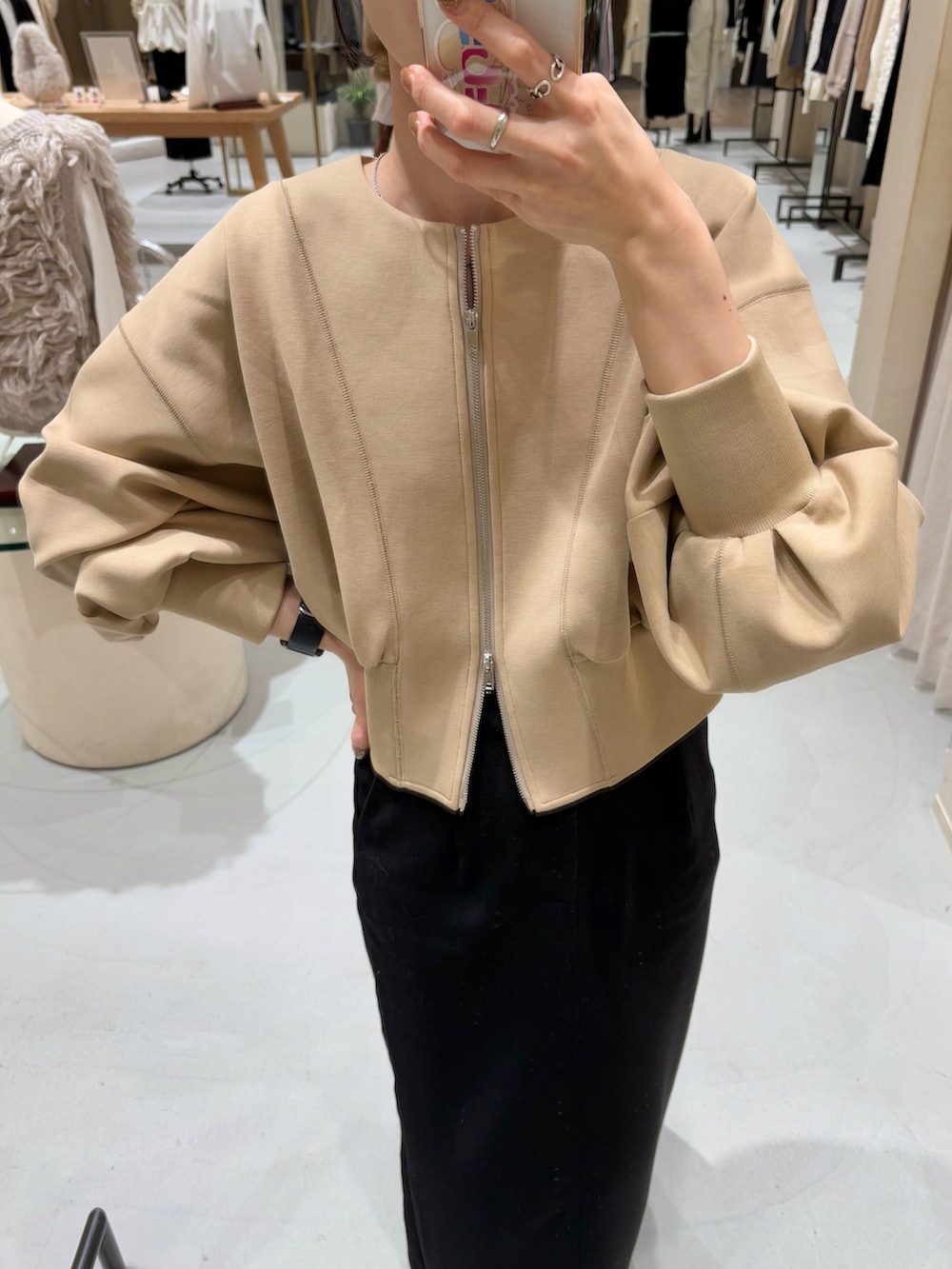 ブラック系のブーツ、ベージュ系のTシャツ/カットソー、ブラック系のバッグを着用したレディースの冬コーディネートの2枚目の写真