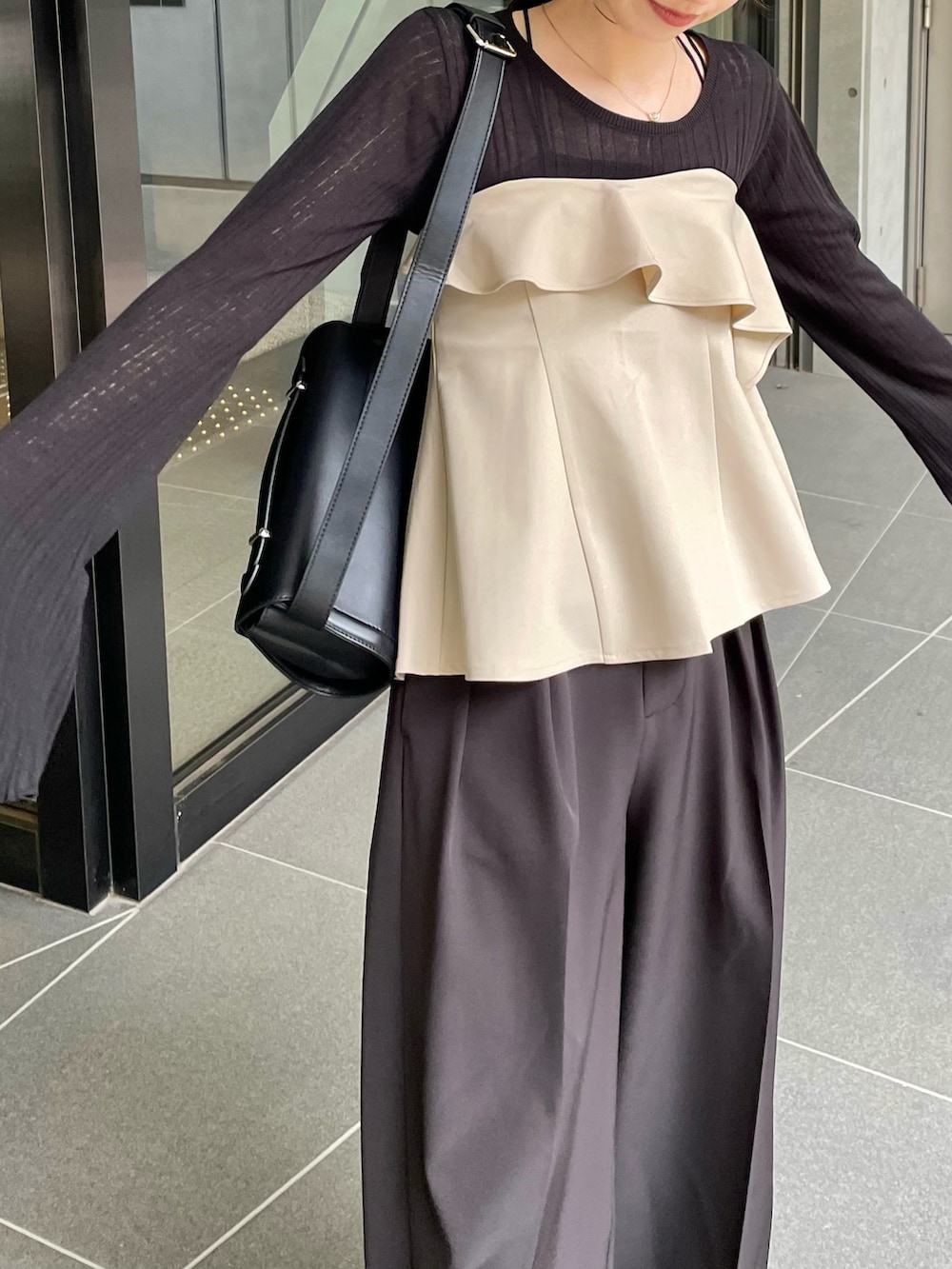 ブラック系のその他パンツ、ベージュ系のシャツ/ブラウス、ブラック系のニット/セーターを着用したレディースの春コーディネートの2枚目の写真