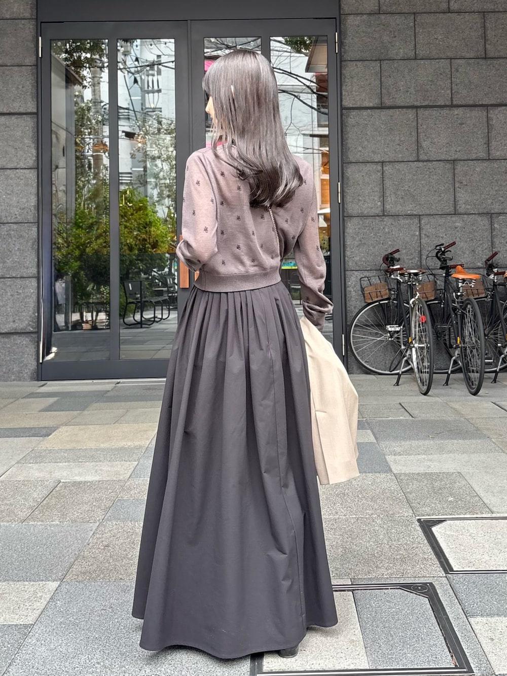 ブラック系のスカート、ブラック系のパンプス、グレー系のカーディガン/ボレロを着用したレディースの春コーディネートの5枚目の写真