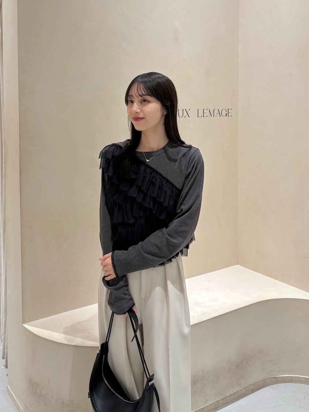 ホワイト系のその他パンツ、グレー系のTシャツ/カットソー、ブラック系のショルダーバッグを着用したレディースの春コーディネートの2枚目の写真