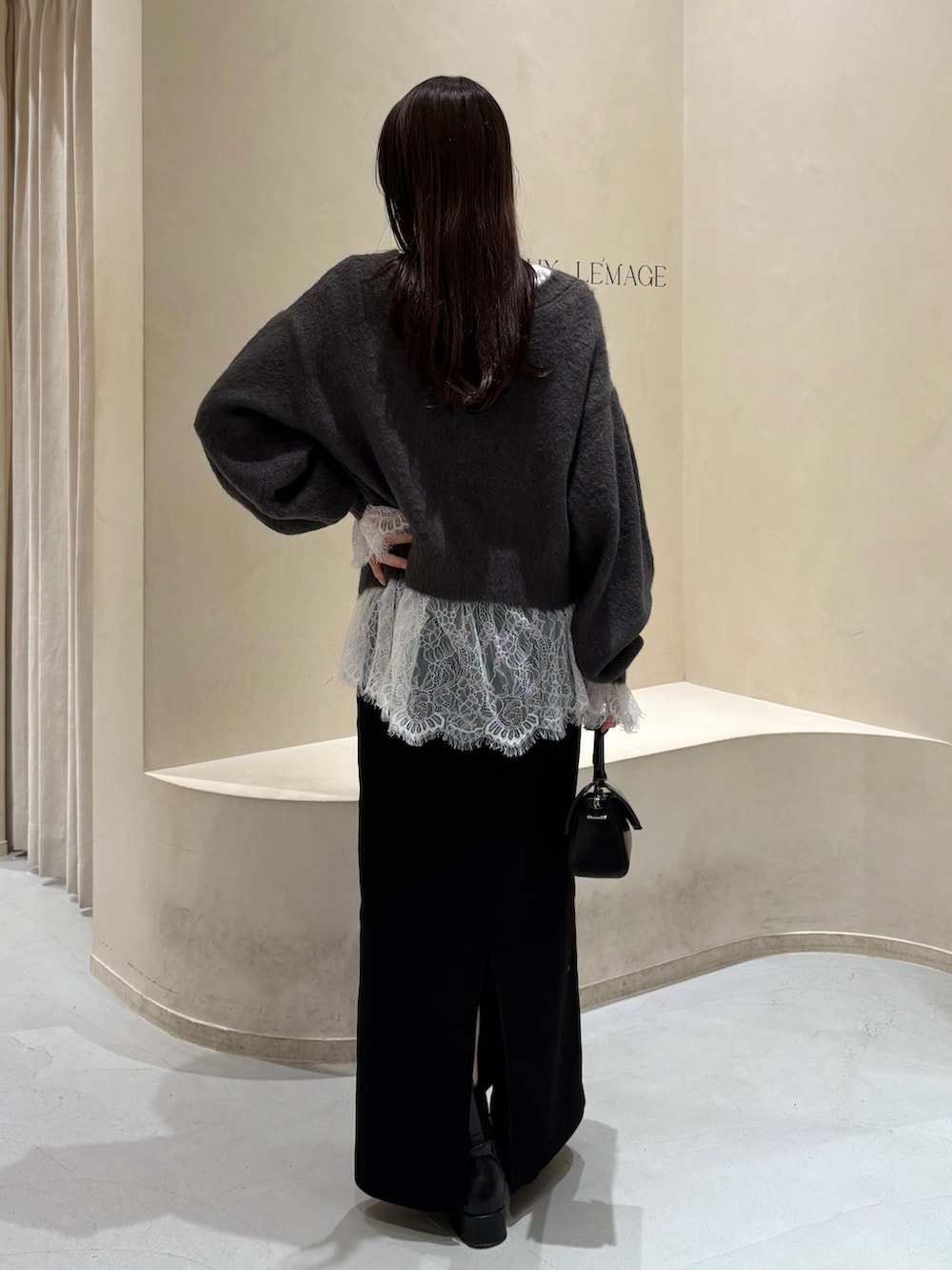 ブラック系のスカート、ブラック系のブーツ、ホワイト系のTシャツ/カットソーを着用したレディースの冬コーディネートの6枚目の写真