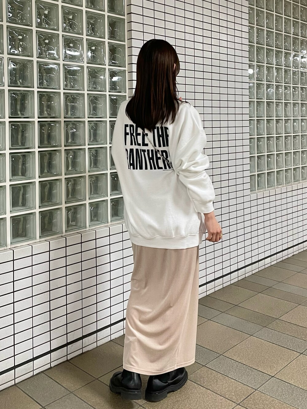 ホワイト系のスウェット、ベージュ系のスカート、ブラック系のトートバッグを着用したレディースの冬コーディネートの3枚目の写真