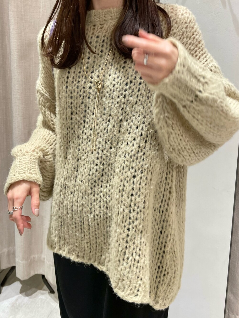 ベージュ系のニット/セーター、ブラック系のワンピース、ブラック系のブーツを着用したレディースの秋コーディネートの2枚目の写真