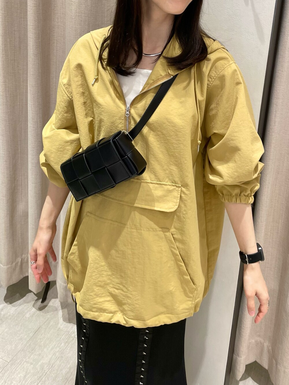 ブラック系のスカート、イエロー系のトップス、ブラック系のボディバッグ/ウエストポーチを着用したレディースの夏コーディネートの2枚目の写真