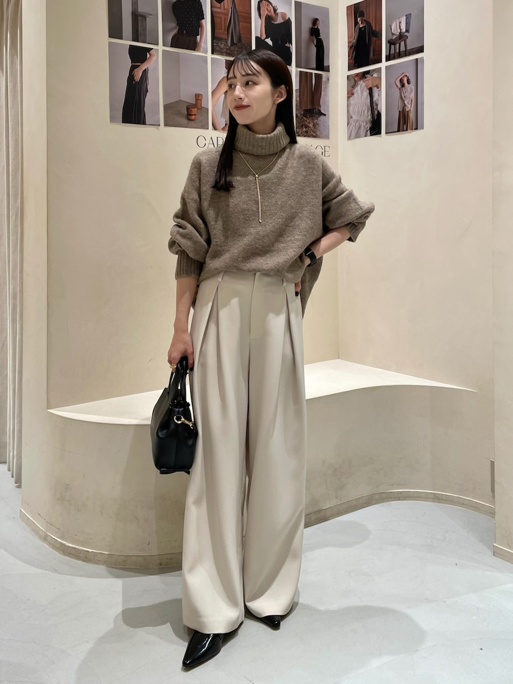 ブラック系のショルダーバッグ、ブラック系のパンプス、ホワイト系のその他パンツを着用したレディースの秋コーディネートの2枚目の写真