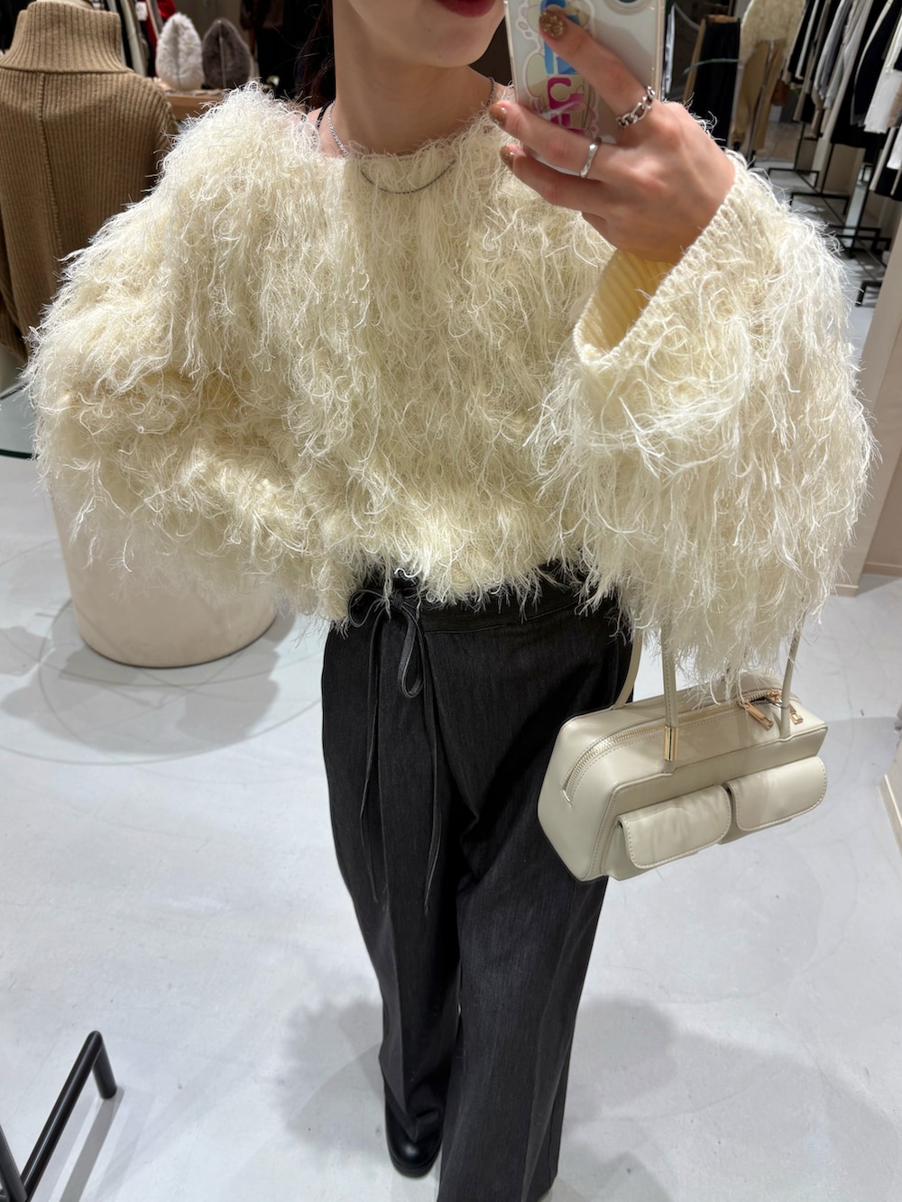 ブラック系のその他パンツ、ホワイト系のニット/セーター、ホワイト系のショルダーバッグを着用したレディースの冬コーディネートの2枚目の写真