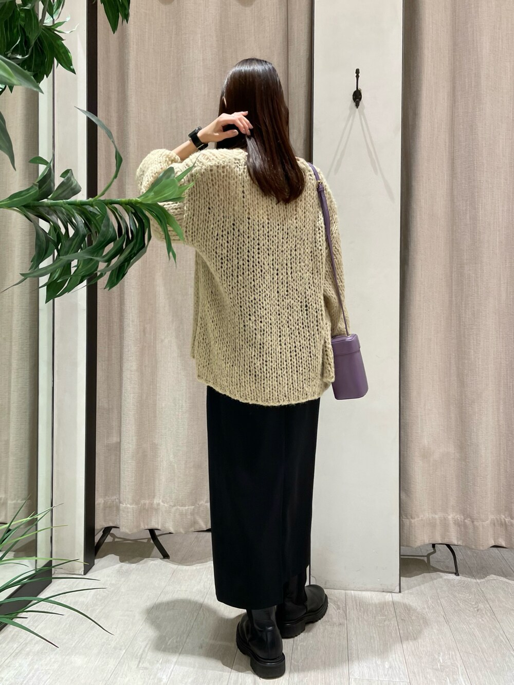 ベージュ系のニット/セーター、ブラック系のワンピース、ブラック系のブーツを着用したレディースの秋コーディネートの3枚目の写真