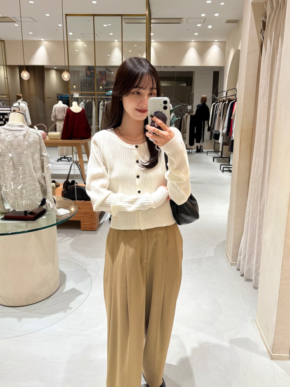 ホワイト系のカーディガン/ボレロ、イエロー系のその他パンツ、ブラック系のショルダーバッグを着用したレディースの冬コーディネートの2枚目の写真