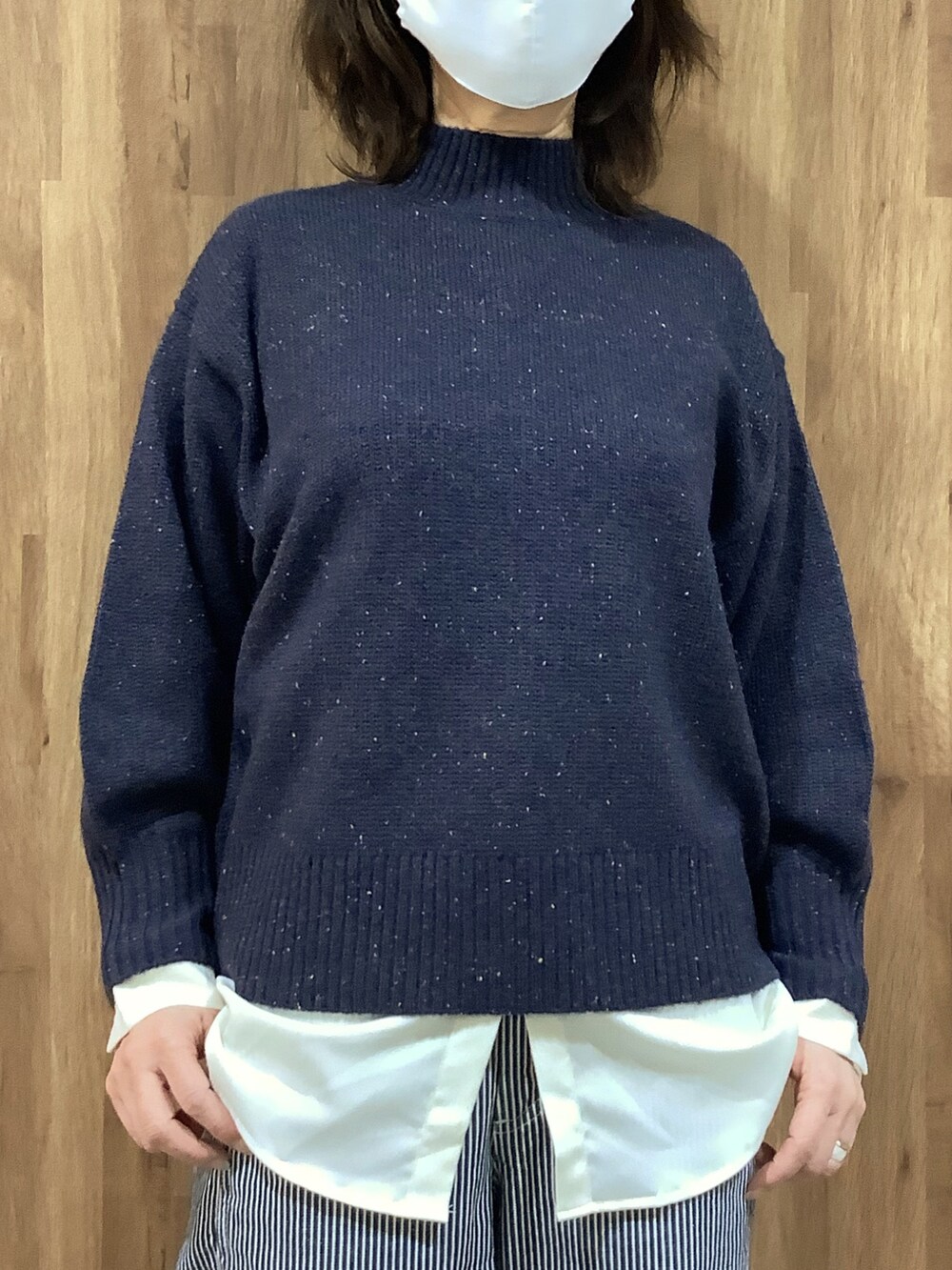 ブルー系のニット/セーター、ホワイト系のシャツ/ブラウスを着用したレディースの冬コーディネートの2枚目の写真