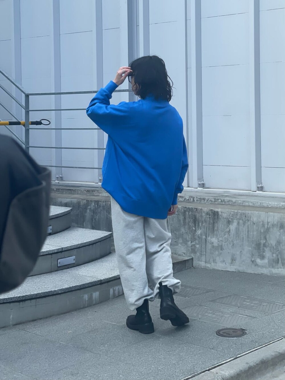 ブルー系のスウェット、グレー系のスウェットパンツ、ブラック系のブーツを着用したレディースの冬コーディネートの3枚目の写真