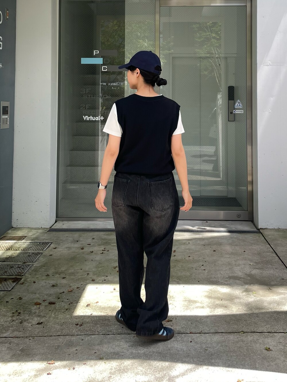 ブラック系のベスト、ブラック系のデニムパンツ、ホワイト系のTシャツ/カットソーを着用したレディースの夏コーディネートの2枚目の写真