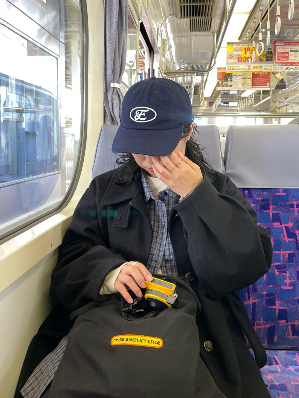 ブラック系のステンカラーコート、ブルー系のシャツ/ブラウスを着用したレディースの冬コーディネートの3枚目の写真