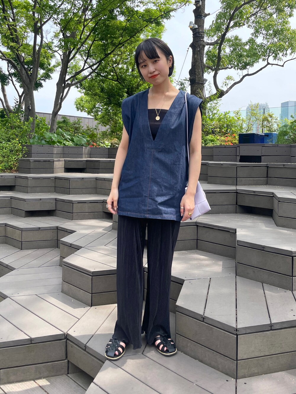 ブラック系のサンダル、ホワイト系のその他パンツ、ブルー系のベストを着用したレディースの春コーディネートの3枚目の写真