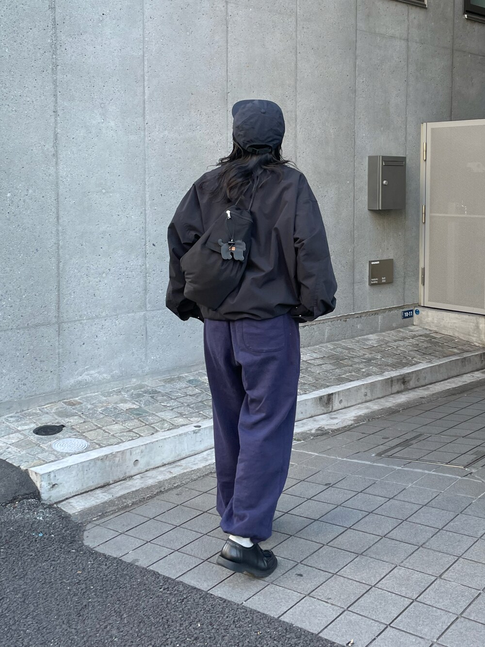 ブルー系のスウェットパンツ、ブラック系のブルゾン、ブラック系のバックパック/リュックを着用したレディースの冬コーディネートの2枚目の写真