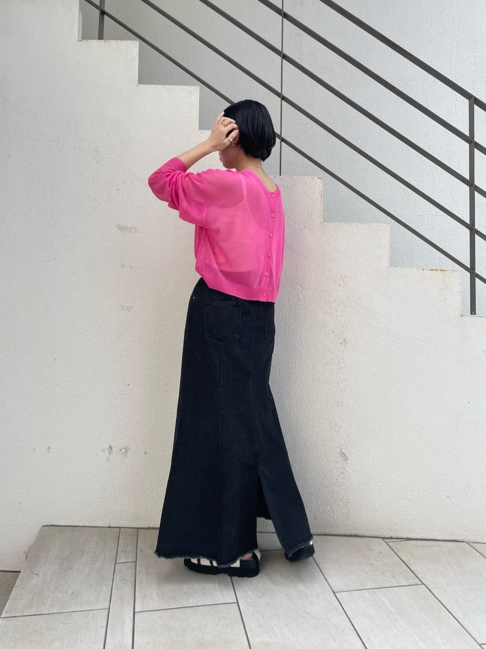 ホワイト系のサンダル、ブラック系のデニムスカート、ブラック系のショルダーバッグを着用したレディースの春コーディネートの2枚目の写真