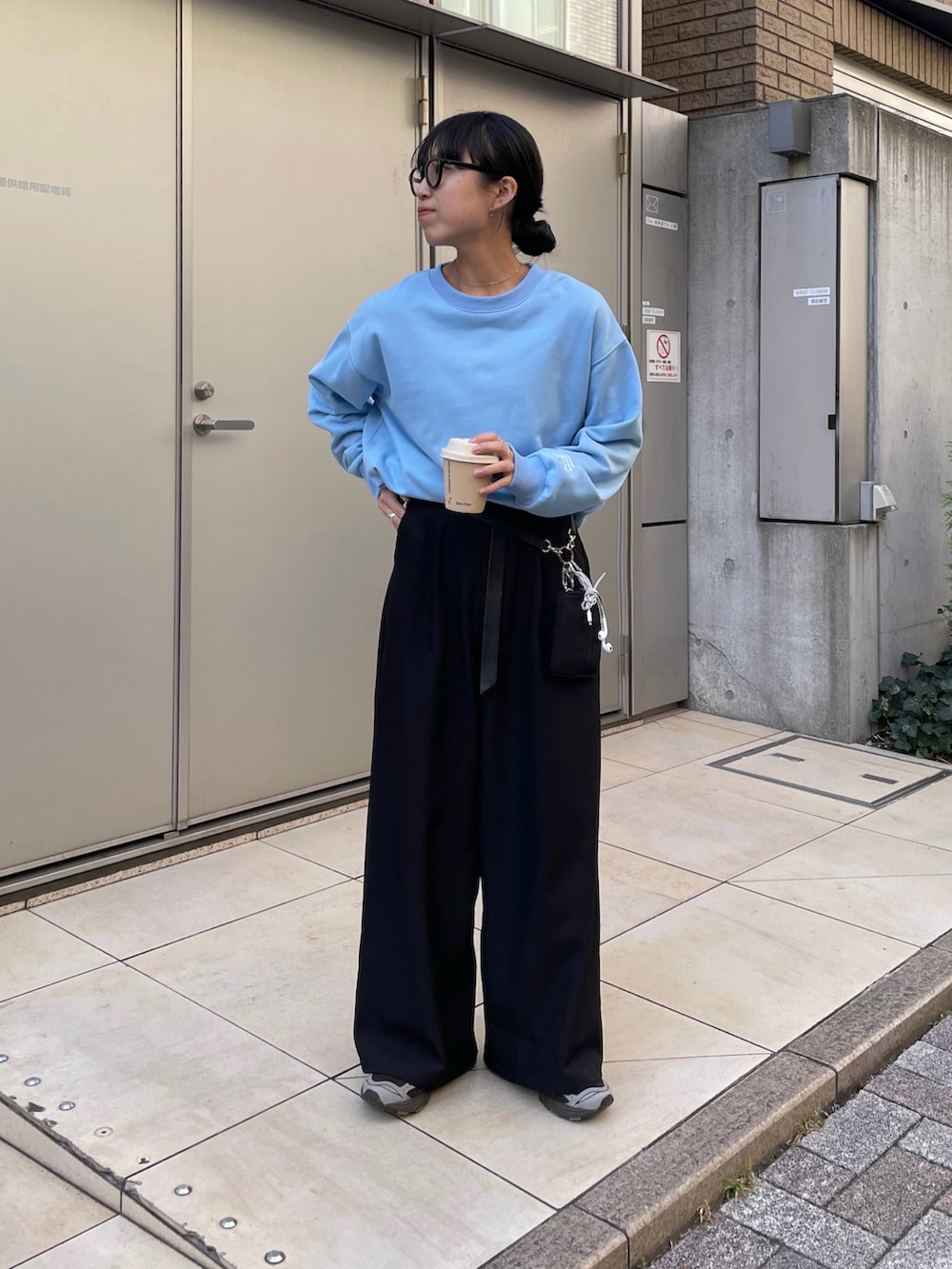 ブラック系のスラックス、ブラック系のショルダーバッグ、ブルー系のスウェットを着用したレディースの秋コーディネートの2枚目の写真