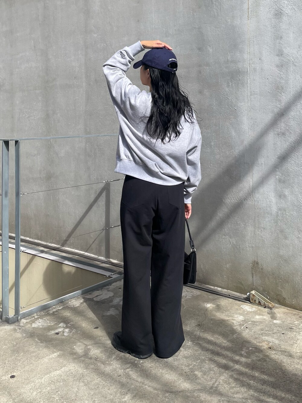グレー系のその他パンツ、ブラック系のハンドバッグ、グレー系のスウェットを着用したレディースの秋コーディネートの2枚目の写真